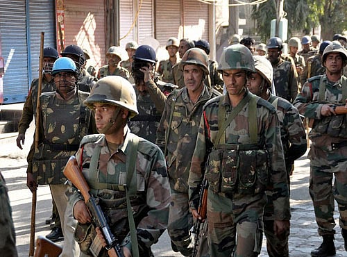 Police personnel stand guard where thousands of shops and private properties of non-Jats were targetted by protesters in Rohtak on Monday. PTI