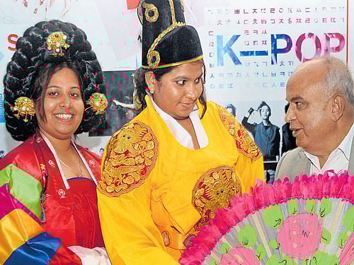 Prof B Thimme Gowda, Vice Chancellor of Bangalore University, with students dressed in traditional South Korean attire at the International Language Fair at the Jnanajyothi Auditorium on Sunday. DH PHOTO