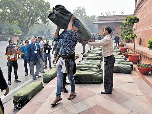 Workers carry documents of Union Budget 2016-17 ahead of its presentation at the Parliament House in New Delhi on Monday. PTI