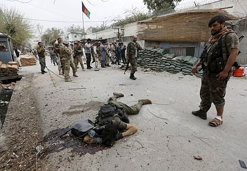 An Afghan security force personnel stands over the dead body of a suicide attacker near the Indian consulate in Jalalabad, Afghanistan. Reuters photo