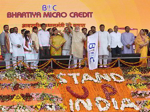 Prime Minister Narendra Modi flagging off E-Rickshaws during distribution of E rickshaws under Pradhan Mantri Mudra Yojana launched under Stand up India Scheme in Noida on Tuesday. PTI Photo.
