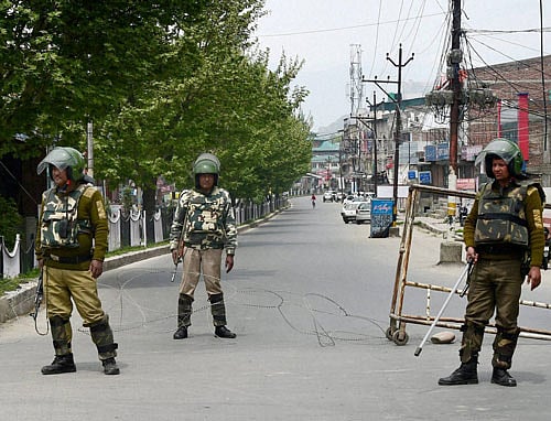 Security jawans guard a deserted street during the 4th consecutive day of strike and restrictions in Srinagar on Saturday. Authorities have imposed restrictions in the view of the strike called by separatists against the killing of five persons in Handwara. PTI Photo