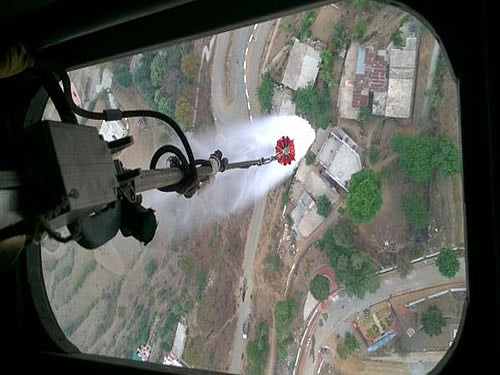 The Mi 17 chopper, which has a capacity to carry 3,000 litres of water, is collecting water from Bhimtal lake and making sorties over Almakhan, Kilbari and Nalena areas of Nainital district to douse the fires. Image courtesy: ANI Twitter