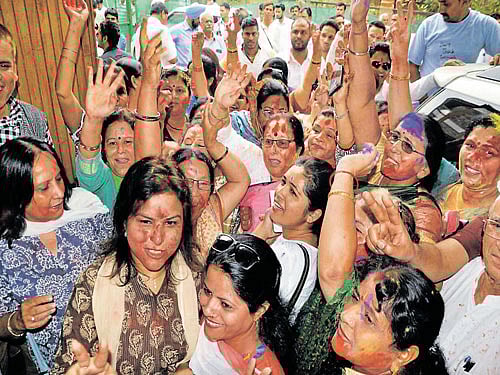Congress workers celebrate with colours in Dehradun on Wednesday after the Supreme Court  approved that Rawat won the trial of strength in the Uttarakhand Assembly. PTI
