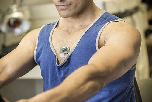 Study co-author Amay Bandodkar wears the Chem-Phys patch while using an exercise bike in a lab at the Center for Wearable Sensors. Credit: Jacobs School of Engineering/UC San Diego