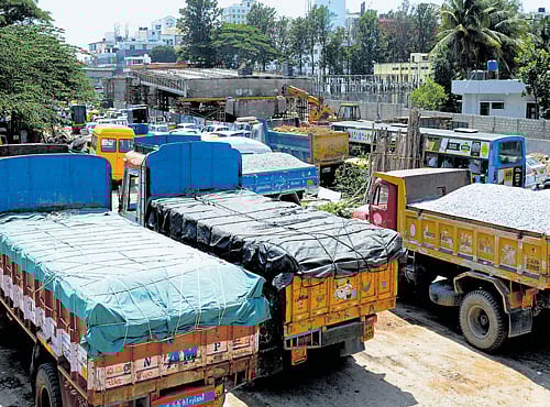 Delay in acquiring the land where the sand lorry stand is situated has slowed downwork on constructing the flyover. DH PHOTO
