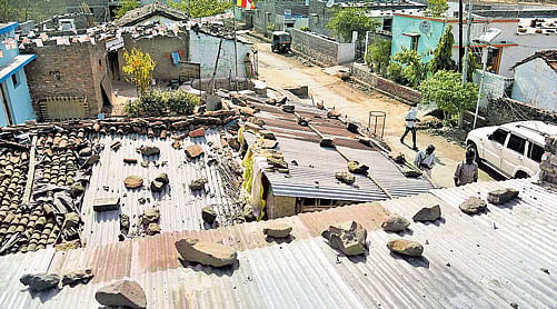 Villagers walk past houses struck by debris from the fire at  ammunition depot in Pulgaon in Maharashtra on Tuesday; PTI Photo