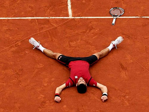 Serbia's Novak Djokovic lays on the clay in a heart in drew after defeating Britain's Andy Murray during their final match of the French Open tennis tournament at the Roland Garros stadium. AP/PTI