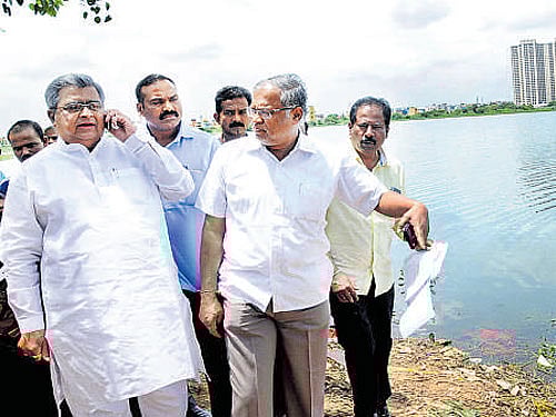 Chairman of House Panel on Lake Encroachment, K B Koliwad, and MLA Suresh Kumar inspect Hulimavu lake in the city on Wednesday. DH Photo