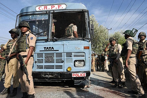 Security forces inspect a CRPF bus which was attacked by militants on Srinagar-Jammu National Highway on the outskirts of Srinagar on Saturday. PTI
