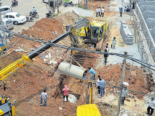 The work on laying a new pipeline to facilitate flow of water from Sarakki lake is in progress at Ashwathnarayan layout on Tuesday. DH Photo