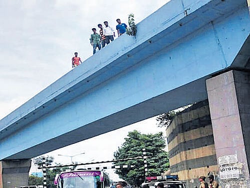 Onlookers at the Salem bridge near Doddanekkundi, from where a man fell to his death on Tuesday.