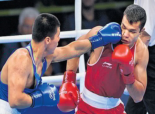 OUCH!! India's Vikas Krishan (right) takes a blow from Uzbekistan's Bektemir Melikuziev on Monday. DH PHOTO