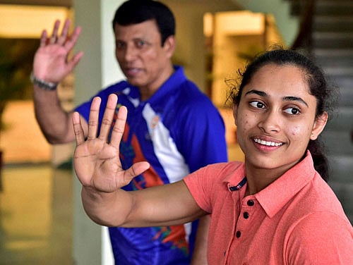 Homecoming: Gymnast Dipa Karmakar and her coach Bishweshwar Nandi wave at fans after arriving in Delhi. PTI