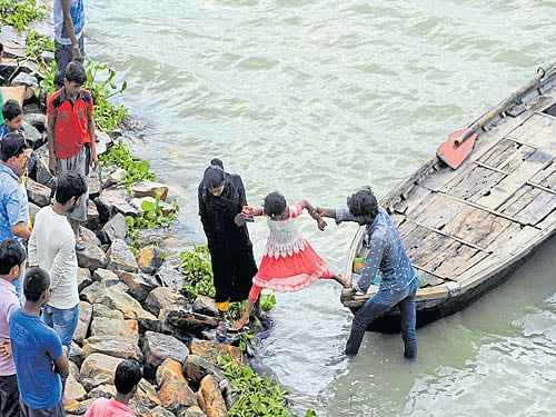 Flood-affected residents of low-lying areas move to dry ground by boat after their houses got flooded in the Teliarganj Pitamber Nagar Area in Allahabad on Monday. AFP