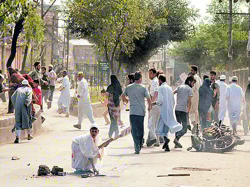 run for cover: People run for safety after a tear gas shell was fired by the police to disperse the protesters. PTI