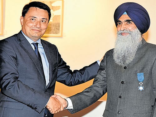 Alexandre Ziegler, French Ambassador to India, confers the French distinction of "Officer of the National Order of Merit" upon Chiranjiv Singh, president of Alliance Francaise and former Ambassador of India to UNESCO in Paris, at a programme in Bengaluru on Wednesday. DH Photo