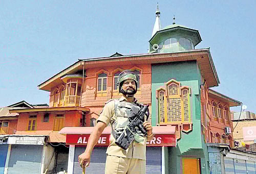 on vigil: A jawan with a 'pellet gun' patrols a deserted street on the 70th day of curfew in Srinagar on Friday. PTI