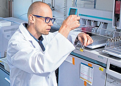 under scrutiny Geneticist Kevin Verstrepen with some beer samples at the gas  chromatograph used to measure aroma compounds at the University of Leuven  in Belgium. photo courtesy: Kevin Verstrepen