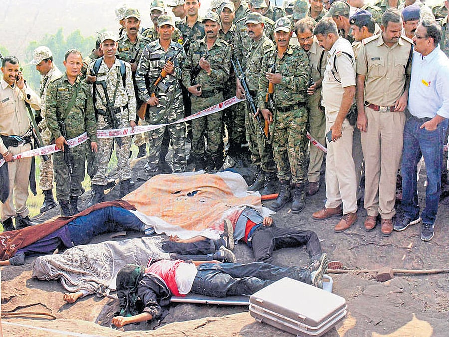 Police personnel gather near the bodies of the Simi  members at the encounter site on the hillocks of Acharpura village in Bhopal on Monday. PTI