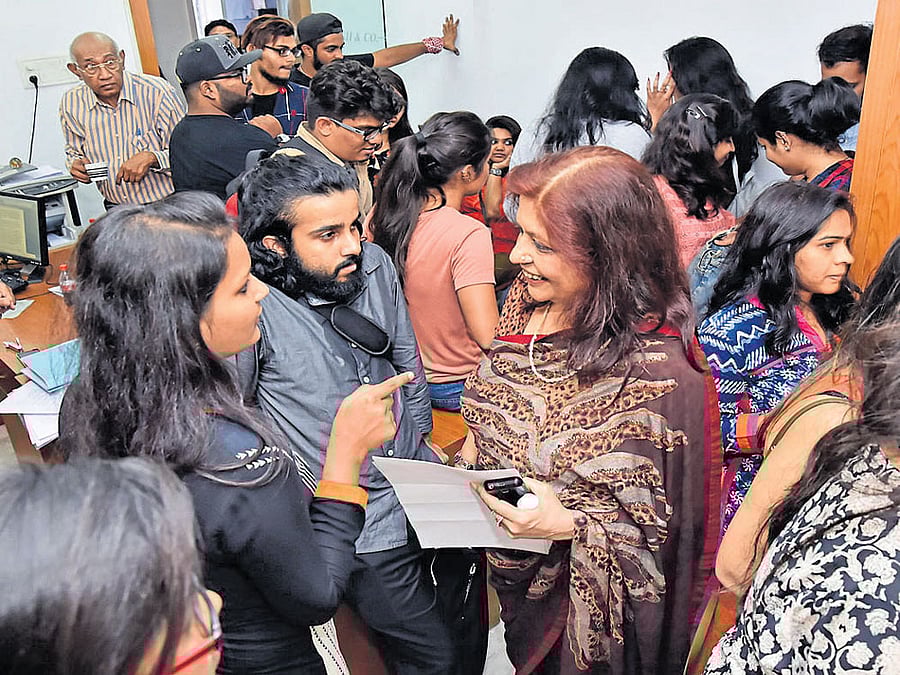 Former minister Nafees Fazal listens to the grievances of students at Raffles Millenium International office at MG Road on Friday. dh photo
