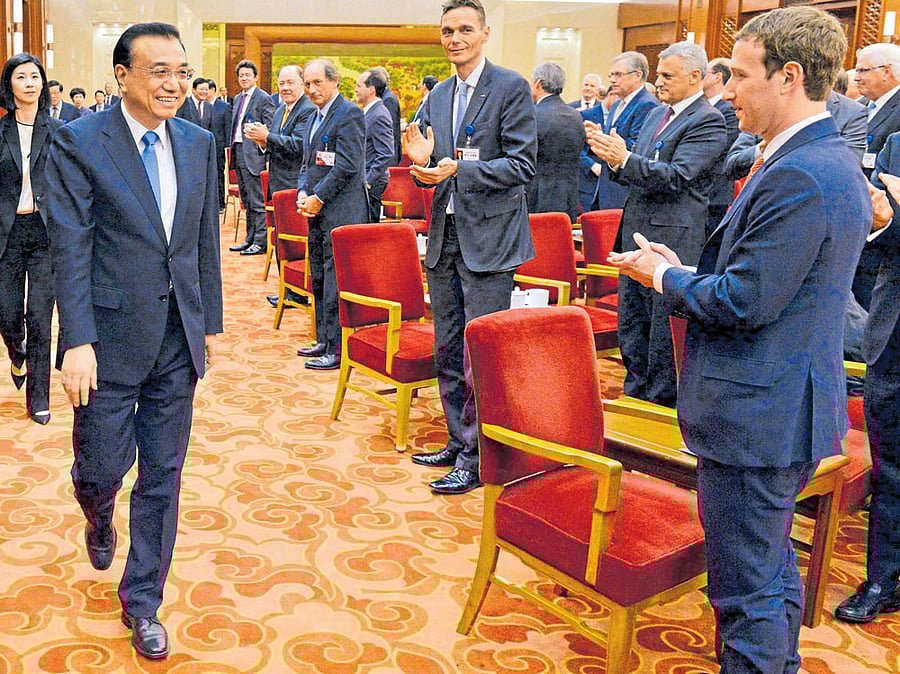 Mark Zuckerberg (right) applauds the arrival of Chinese Premier Li Keqiang at Great Hall of the People in Beijing.  Facebook has created a censorship software in a bid to gain access to the vast Chinese market. REUTERS