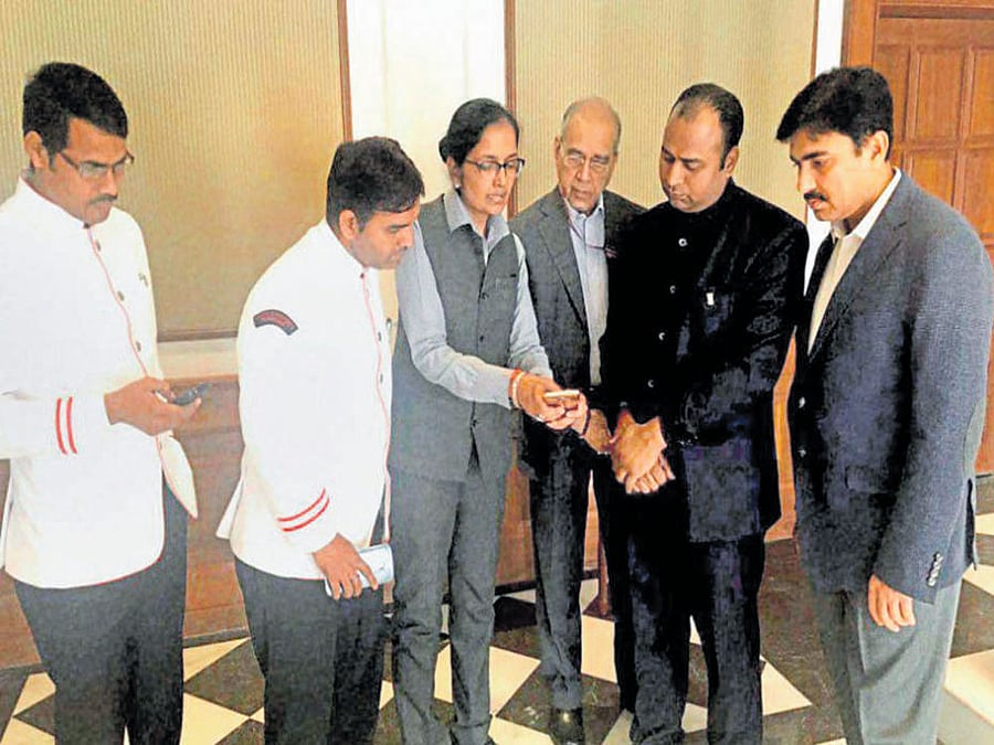 Prime Minister's Office staff explain the concepts of mobile banking and cashless transactions in New Delhi. PTI