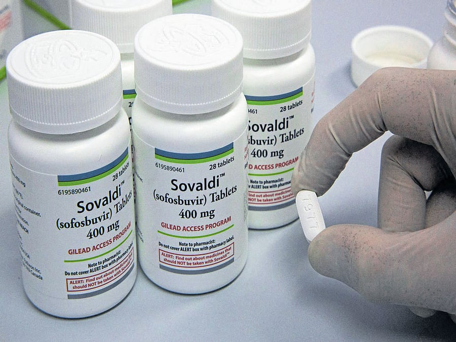 lethal dose: A pharmacist holds a pill of the antiviral drug Sovaldi at the National Liver Institute in Cairo. A new report suggests drugs approved in recent years that can cure hepatitis C may have severe side effects, including liver failure. nyt