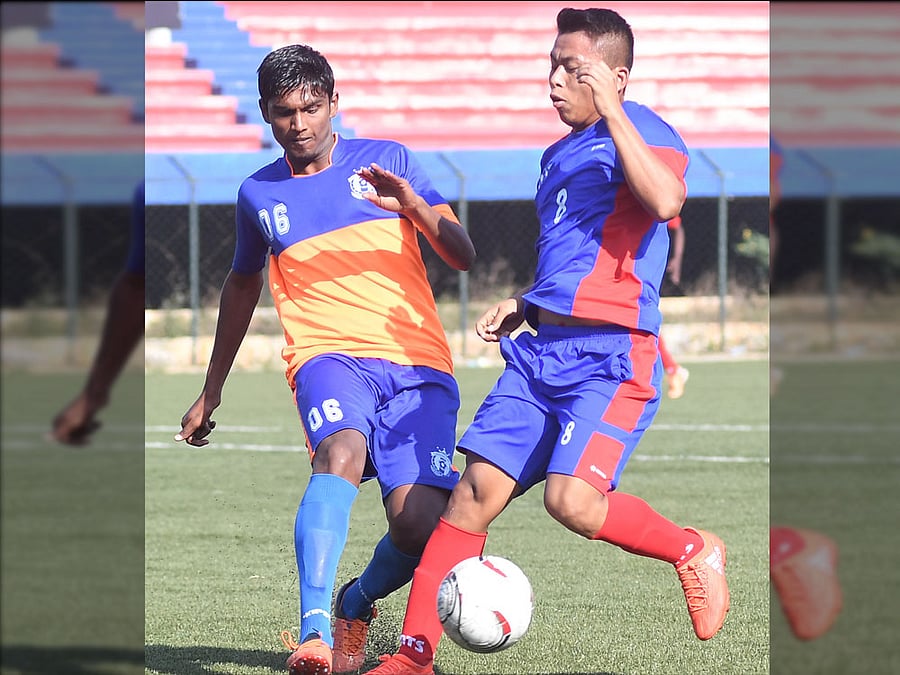 Intense battle: MEG medio Christopher (right) attempts to get past DYES' Ganesh in the Super Division. DH PHOTO