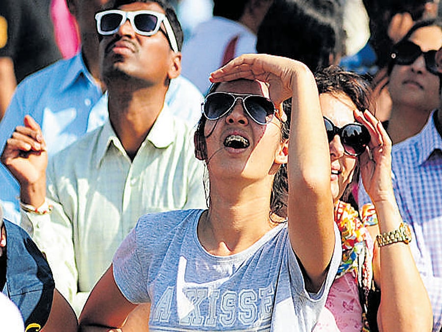 Visitors watch an air display on the final day of Aero India 2017. dh photos / Ranju P