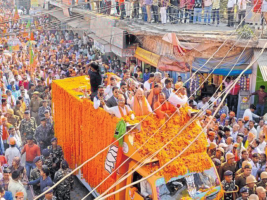 BJP president Amit Shah with party MP Yogi Adityanath during an election roadshow in Gorakhpur on Thursday. PTI