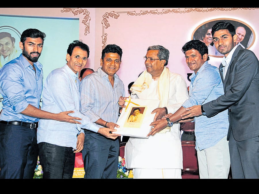 Late thespian Rajkumar's grandson Vinay Rajkumar, sons Raghavendra Rajkumar, Shivarajkumar, Puneeth Rajkumar and grandson Guru Raghavendra Rajkumar felicitate Chief Minister Siddaramaiah at the inauguration of Dr Rajkumar Academy for Civil Services in the city on Sunday. dh photo