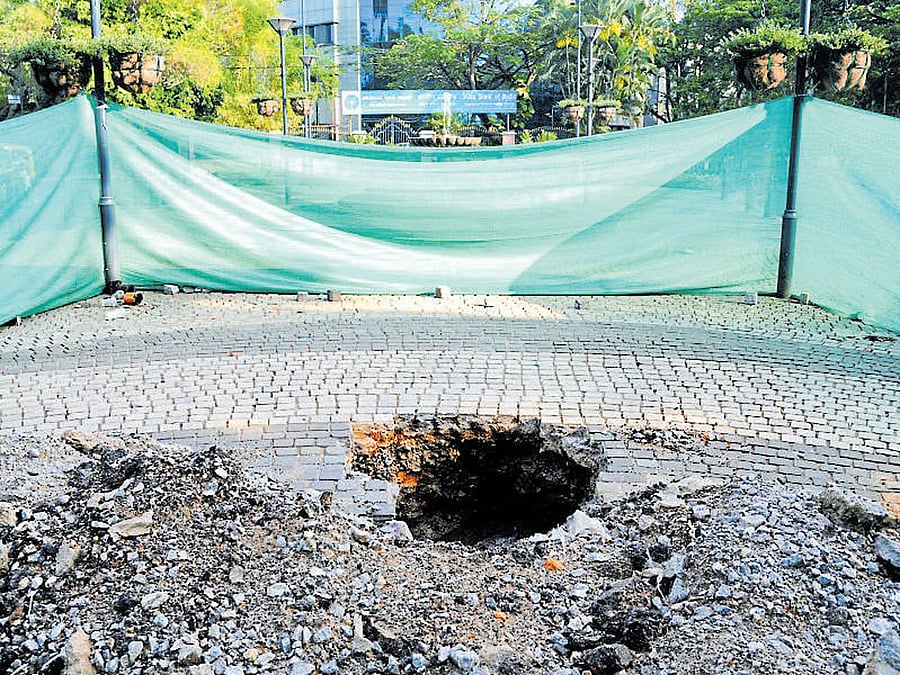 A pit dug up on the footpath near SBI office on St Mark's Road to repair an electricity line. DH Photo