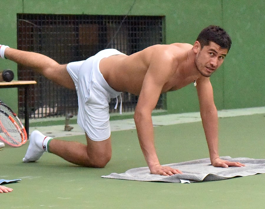 Challenger: Farrukh Dustov of Uzbekistan stretches after a training session on Sunday. DH PHOTO/ BK Janardhan