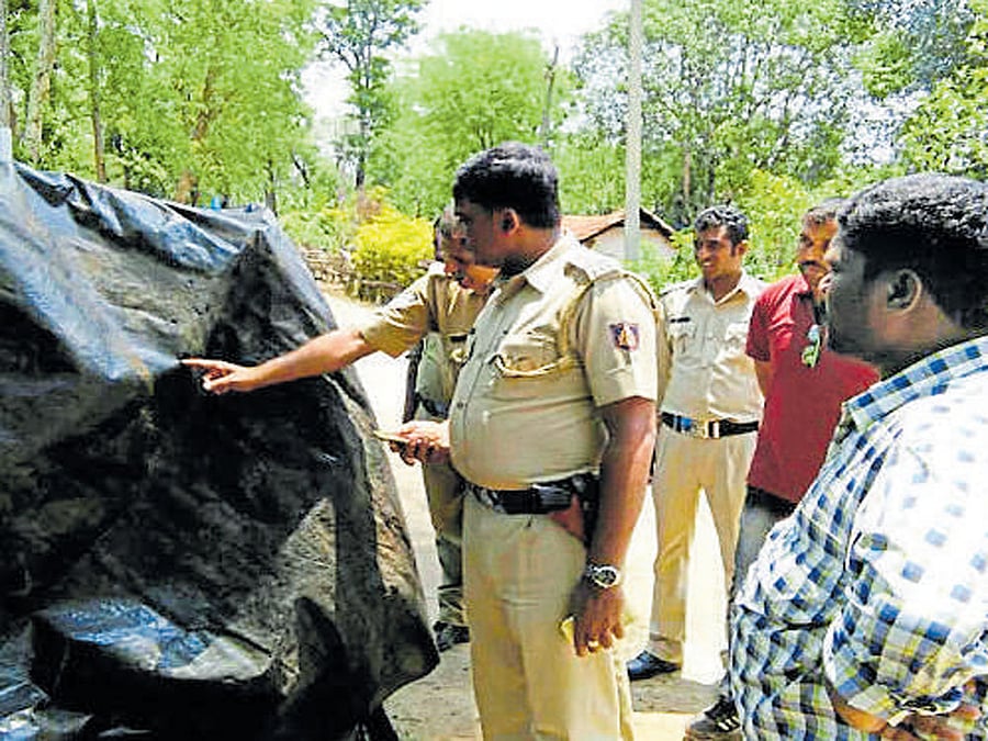 Police inspect the place where a coffee estate owner had fired at the hut belonging to displaced tribals of Diddalli.