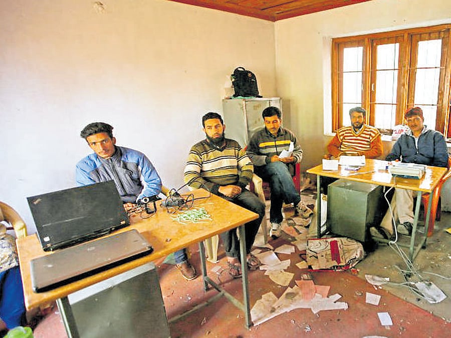 Officials wait for voters to turn up at a polling booth in Wathora in Kashmir on Thursday. Reuters