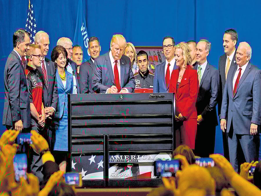 altering market: US President Donald Trump signs the 'Buy American, Hire American' executive order in Kenosha, Wisconsin on Tuesday. The order authorises studies and tweaks in the rules that could lead to restrictions on high-skilled non-American workers. NYT