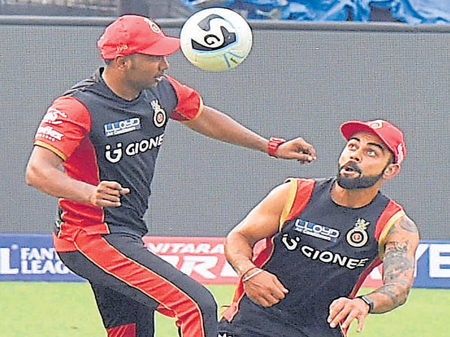 warming up Skipper Virat Kohli (right) and Samuel Badree during RCB's training session in Kolkata on Saturday. afp