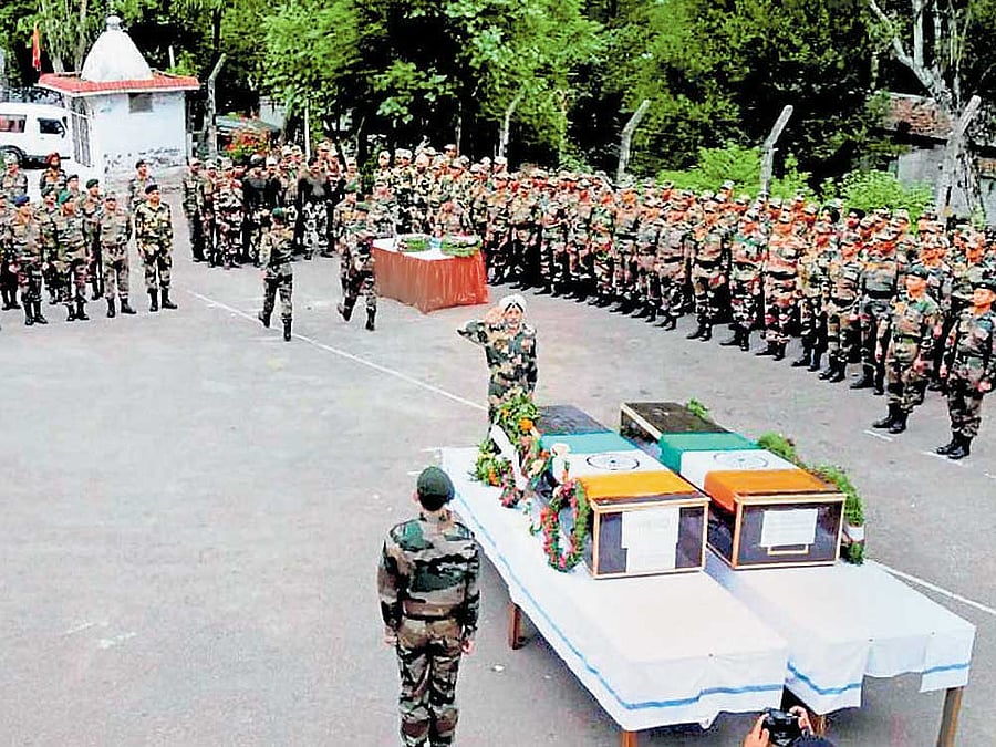A senior army official pays tribute to martyrs Paramjeet Singh and Prem Sagar in Jammu on Tuesday. PTI