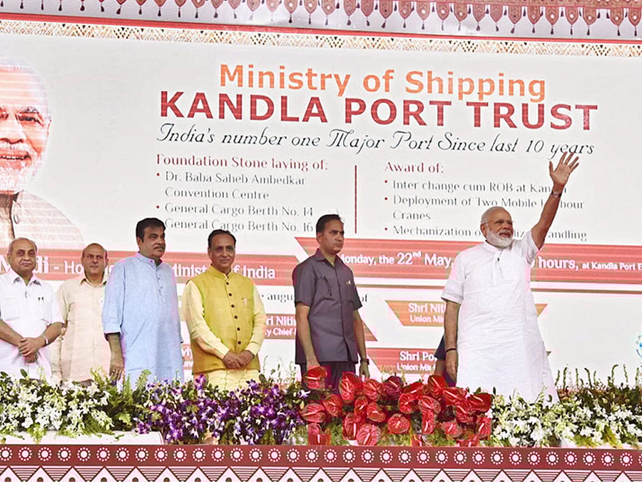 Prime Minister Narendra Modi waves at the unveiling of the digital plaque to mark the foundation stone laying of Development of 14th and 16th General Cargo Berth of Kandla Port, in Gandhidham, Gujarat on Monday. Union Minister for Road Transport & Highways and Shipping, Nitin Gadkari, the Chief Minister of Gujarat, Vijay Rupani, the Minister of State for Road Transport & Highways, Shipping and Chemicals & Fertilizers, Mansukh L. Mandaviya, the Minister of State for Road Transport & Highways and Shipping, P. Radhakrishnan are also seen. PTI Photo