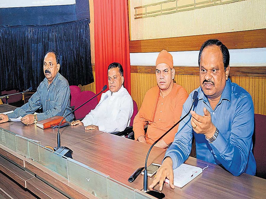 Zilla panchayat chief executive officer Dr M R Ravi speaks at a meeting convened to discuss preparations to observe World Environment Day. Ramakrishna Mutt (Mangaluru) seer Swami Ekagamyananda, Bantwal Taluk Panchayat president Chandrahas Karkera and ZP deputy secretary N R Umesh look on. DH photo