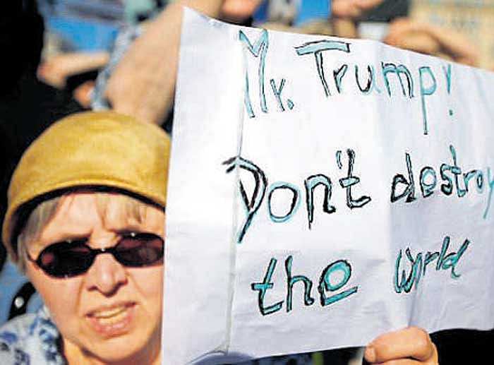 A woman holds a banner against US' withdrawal from the Paris climate change  accord, at the US embassy in Berlin, Germany, on Friday. REUTERS