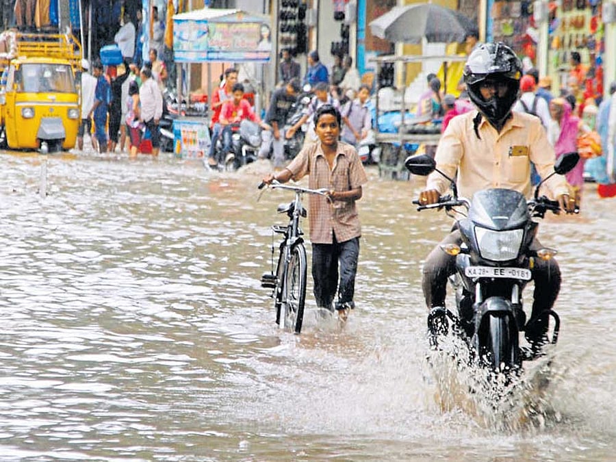 Motorists found it difficult to navigate through KC Market Road which was inundated following heavy rainfall in Vijayapura on Thursday. DH Photo