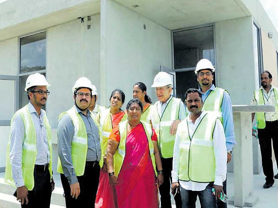 Mayor G&#8200;Padmavathi in front of a model of the Indira  Canteen at KEF Infrastructure, a multinational company, which is fabricating the canteens at Krishnagiri, Tamil Nadu.