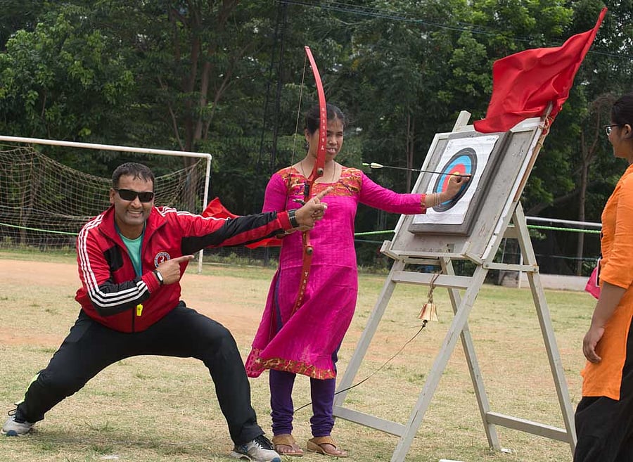 A volunteer exults after a visually challenged participant hits the target by following the sound of the bell hung below it.