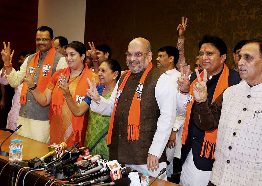(Left to right) BJP state president Jitu Vaghani, union minister Smriti Irani, former chief minister Anandiben Patel, BJP president Amit Shah, party leader Balwantsinh Rajput and Gujarat Chief Minister Vijay Rupani show victory signs after filing nominations for Rajya Sabha polls in Gandhinagar on Friday. PTI Photo