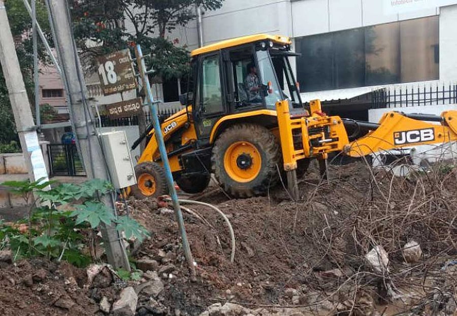 Residents of HSR Layout 9th main took matter into their own hands, bringing in JCBs to remove muck and debris from the SWD, in Bengaluru on Sunday. DH Photo