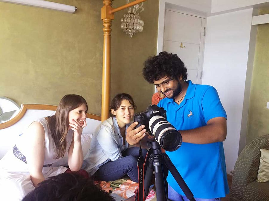 Tanmay at work as two artistes watch.