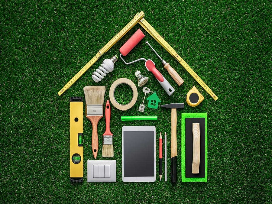 Home renovation, remodeling and DIY concept, work tools and tablet composing a house shape on the grass renovation