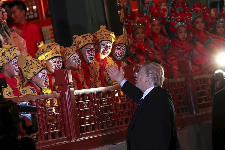 President Donald Trump, center, talks to opera performers, accompanied by Chinese President Xi Jinping, as they tour opera performance at the Forbidden City, Wednesday